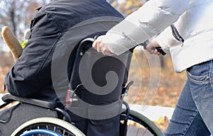 Woman pushing a disabled man in a wheelchair