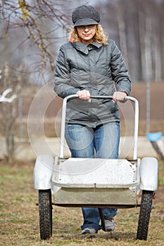 Woman pushing empty barrow