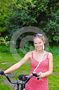 Woman pushing her bike in the woods