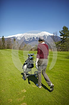 Woman pushing her golf bag trolley