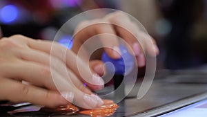 Woman pushing orange buttons of retro arcade machine - close up view