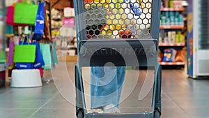 Woman pushing a shopping cart in a supermarket store in slow motion shot