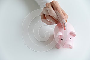 Woman put coin in piggy bank saving money