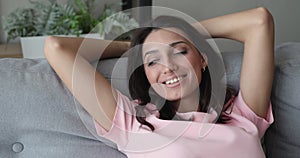 Woman put hands behind head daydream rest lean on sofa