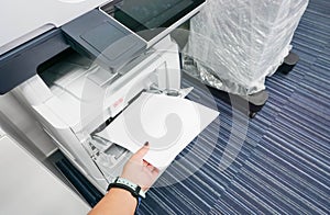 Woman put paper into printer for documents