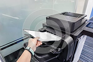 Woman put paper into printer feeder