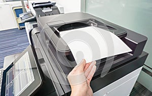 Woman put paper sheet into printer