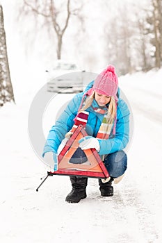 Woman put reflector triangle car breakdown winter