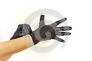 Woman puts on black sterile medical gloves
