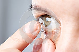 Woman puts contact lens