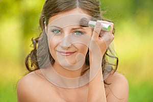 Woman puts on face powder brush