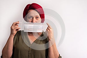 A woman puts on a medical protective mask.