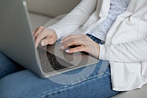 Woman puts notebook on laps do remote job distantly closeup