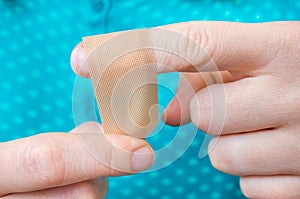 Woman puts a plaster on her injured finger