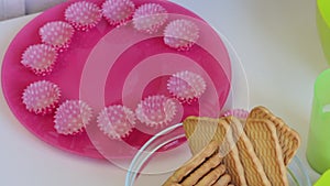 A woman puts on a plate paper molds, which put homemade candy.