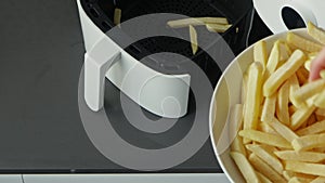 Woman puts raw french fries in bowl of air fryer