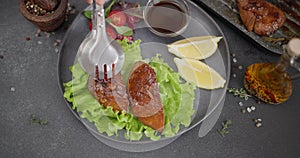 Woman puts salad into plate with Fried pieces of grilled Organic Tuna Steak