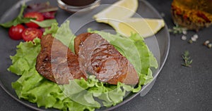 Woman puts salad into plate with Fried pieces of grilled Organic Tuna Steak