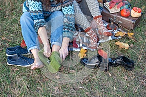 Woman puts on socks while sitting on a plaid