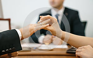 Woman puts a wedding ring in a registry office for a man. Marriage and hands close-up against the background of the ceremony maste