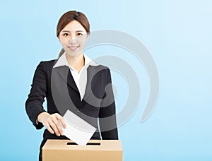 Woman putting ballot into voting box