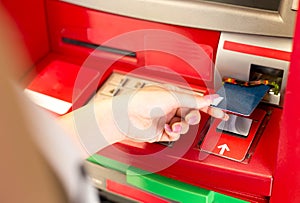 Woman putting card in ATM cash machine