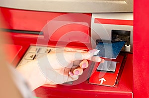 Woman putting card in ATM cash machine