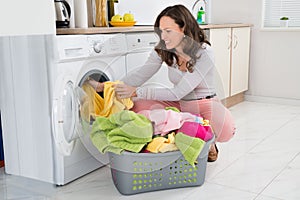 Woman Putting Clothes Into Washing Machine