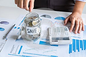 Woman putting coin in bottle for step up growing business to profit and saving with money box, Saving money for future plan and