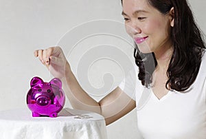 Woman putting a coin into money box