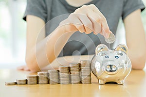 Woman putting a coin into a money-box-close u