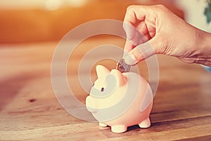Woman putting coins to piggy bank Savings and loan crisis Saving money is key to financial independence