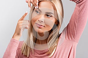 Woman putting contact lens in eye