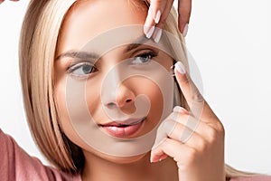 Woman putting contact lens in eye