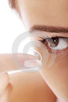 Woman putting contact lens in her eye