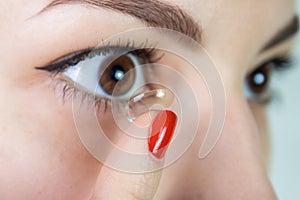 Woman putting contact lens in her eye concept of healthcare