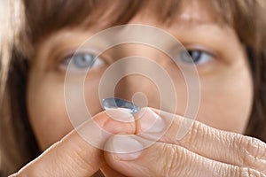 Woman putting contact lens (selective focus used)