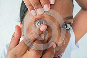 Woman putting on on contact lenses