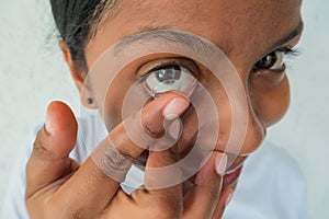 A woman putting on contact lenses, close up