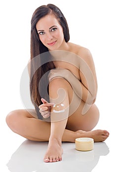 Woman putting cream on her legs