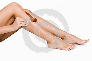 Woman putting depilatory wax on her leg photo