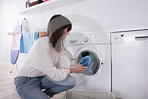 Woman Putting Dirty Cloth Into Washing Machine