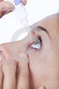 Woman putting drops in the eye