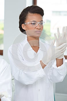 woman putting on goggles and gloves