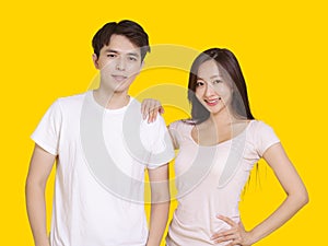 Woman putting her hand on male shoulder.Isolated on yellow background