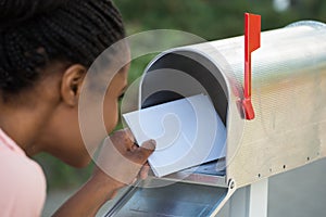 Woman Putting Letter In Mailbox