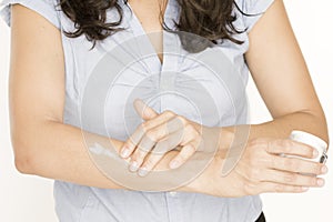 Woman putting lotion on her arm