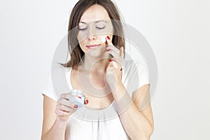 Woman putting lotion on her face