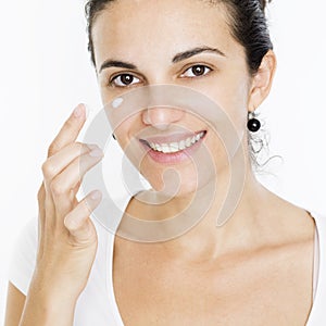 Woman putting lotion on her face