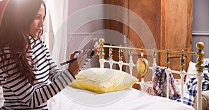 Woman Putting On Make Up In Bedroom